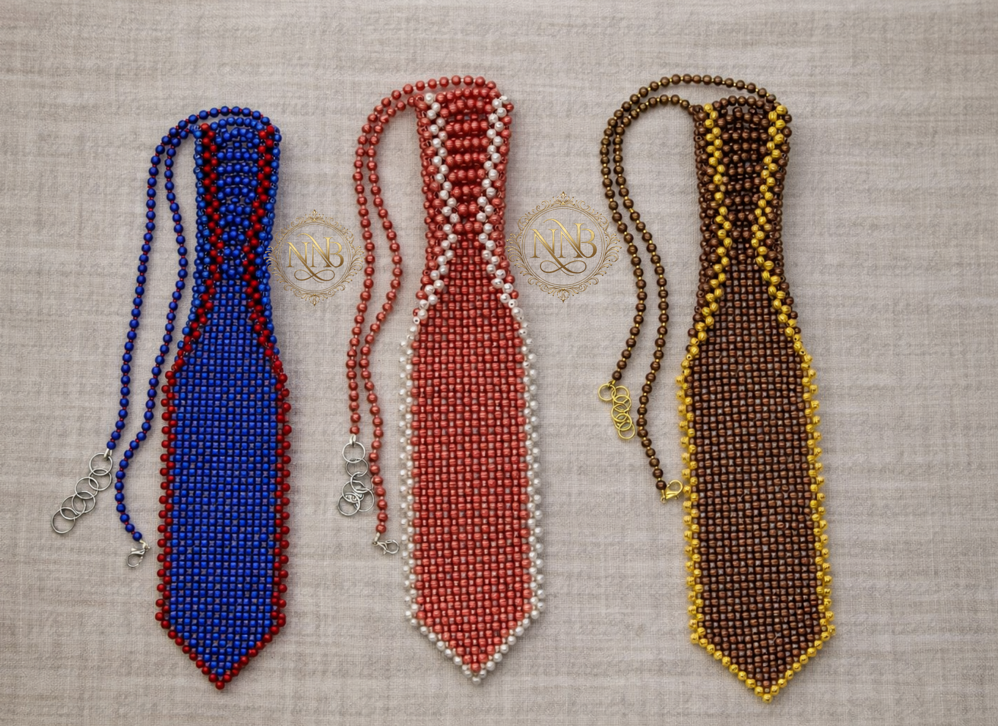 Three handcrafted beaded neckties by NicNacBooteek displayed on a neutral linen background, featuring blue and red, coral and pearl, and brown and gold colorways.