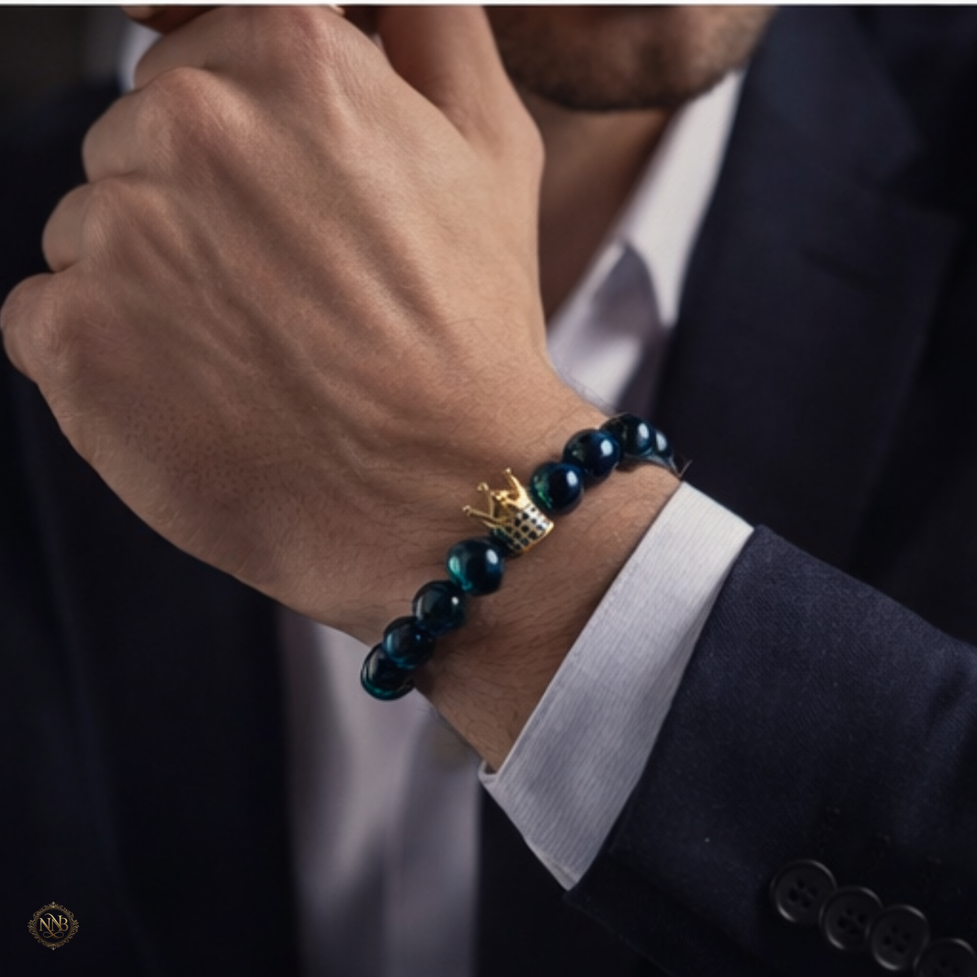 Man wearing 10mm blue tiger eye crown bracelet with navy suit sleeve visible