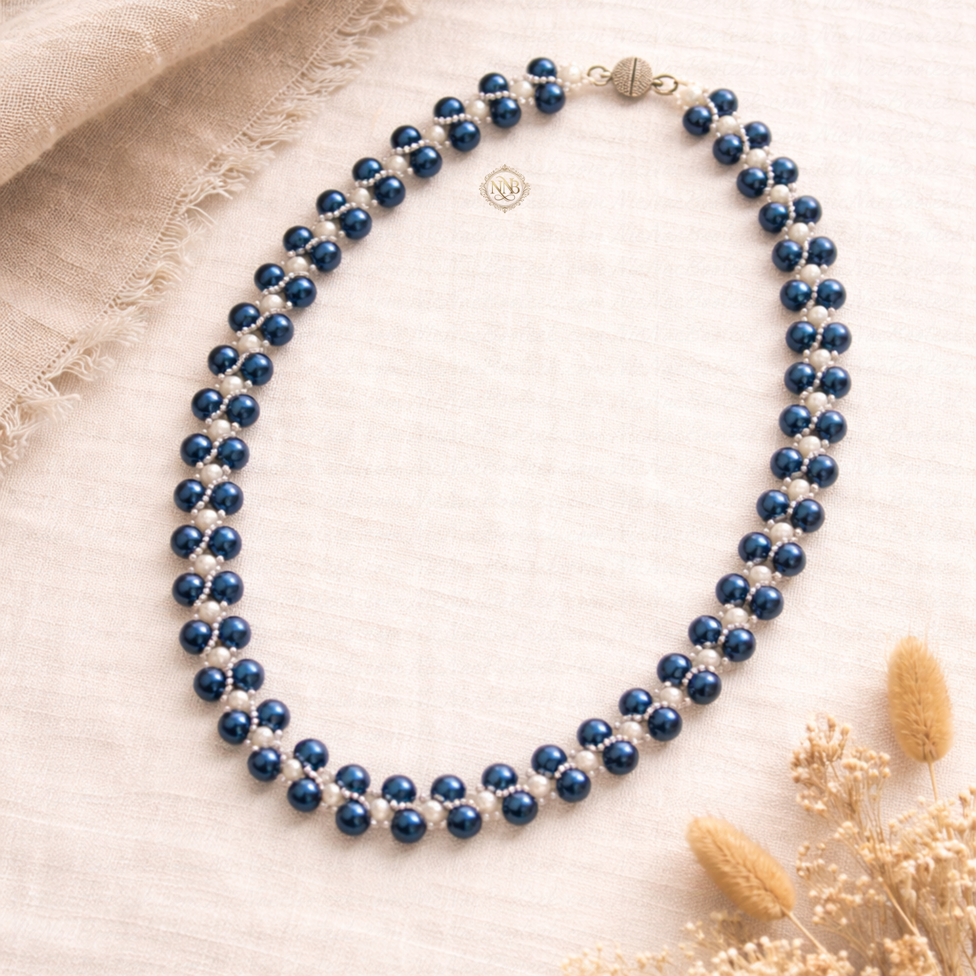Handcrafted blue and white beaded necklace with a woven pattern and magnetic clasp, measuring approximately 21 inches in length on a clean background.