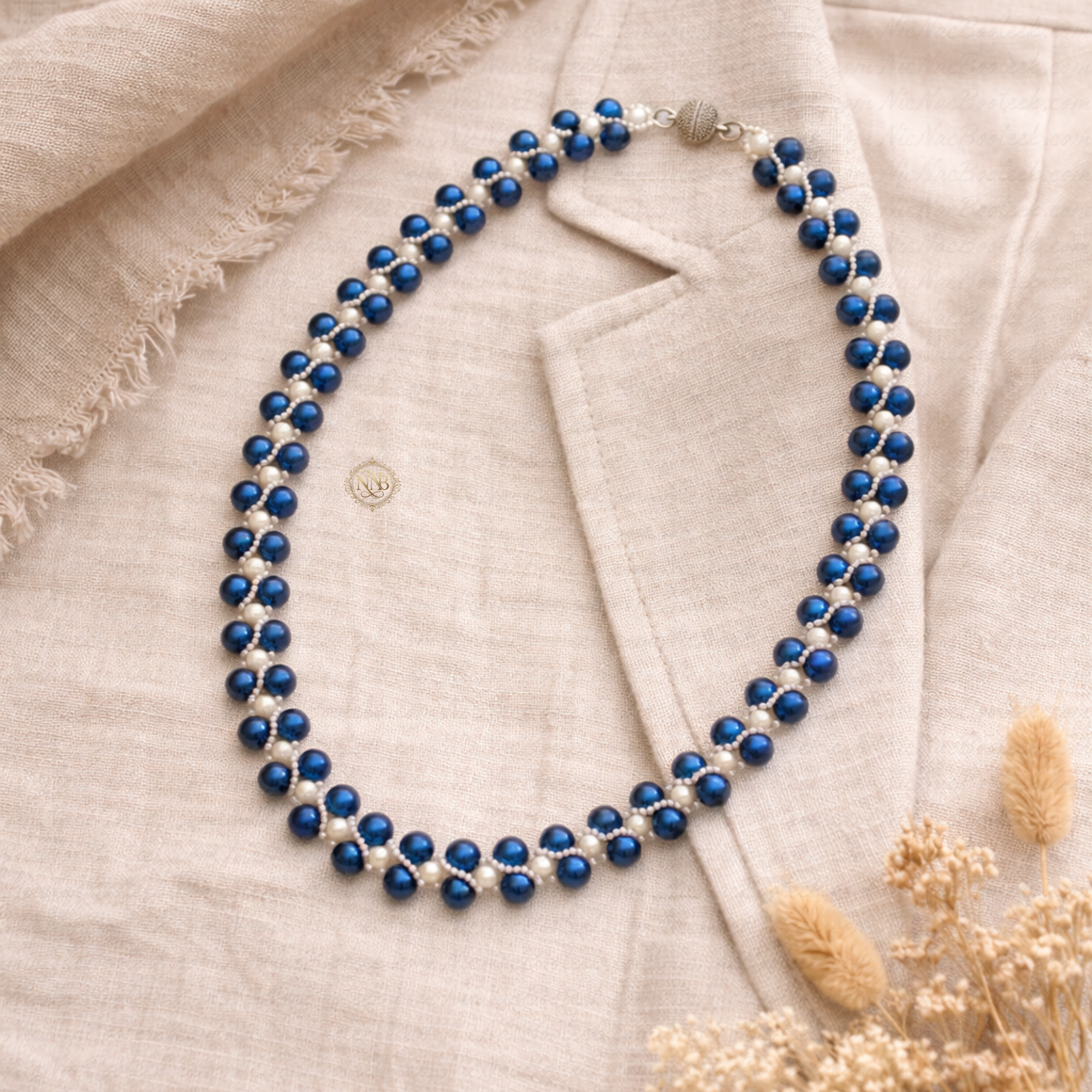 Handcrafted blue and white beaded necklace with a woven pattern and magnetic clasp, measuring approximately 21 inches in length on a clean background.