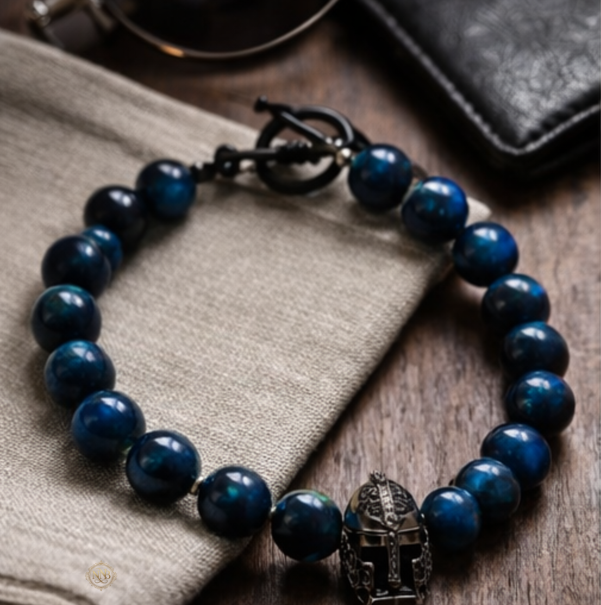 Detail view of tiger's eye 11mm beaded bracelet with warrior helmet centerpiece and black toggle clasp.