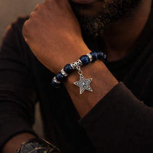 Editorial lifestyle image of man wearing 12mm 12mm Blue Tiger’s Eye stone stretch bracelet finished with silver rhinestone spacers and a polished silver star charm.