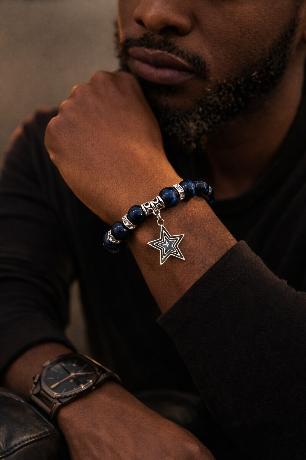Editorial lifestyle image of man wearing 12mm 12mm Blue Tiger’s Eye stone stretch bracelet finished with silver rhinestone spacers and a polished silver star charm.