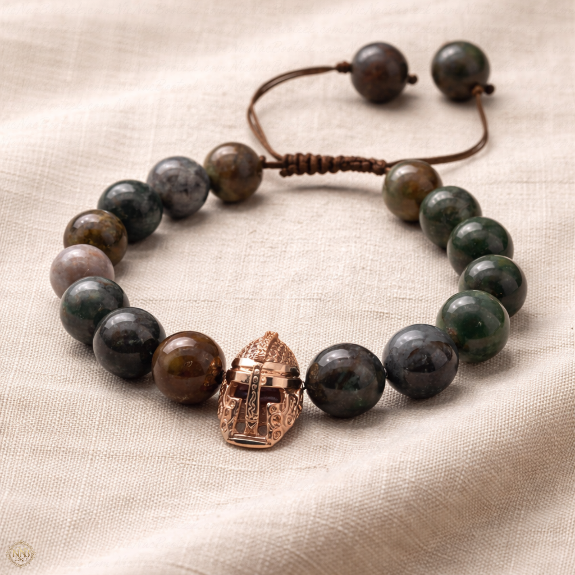 Verdant Vanguard bracelet with 12mm natural agate stone beads and rose gold tone Viking helmet centerpiece, styled on soft neutral linen fabric in natural light.