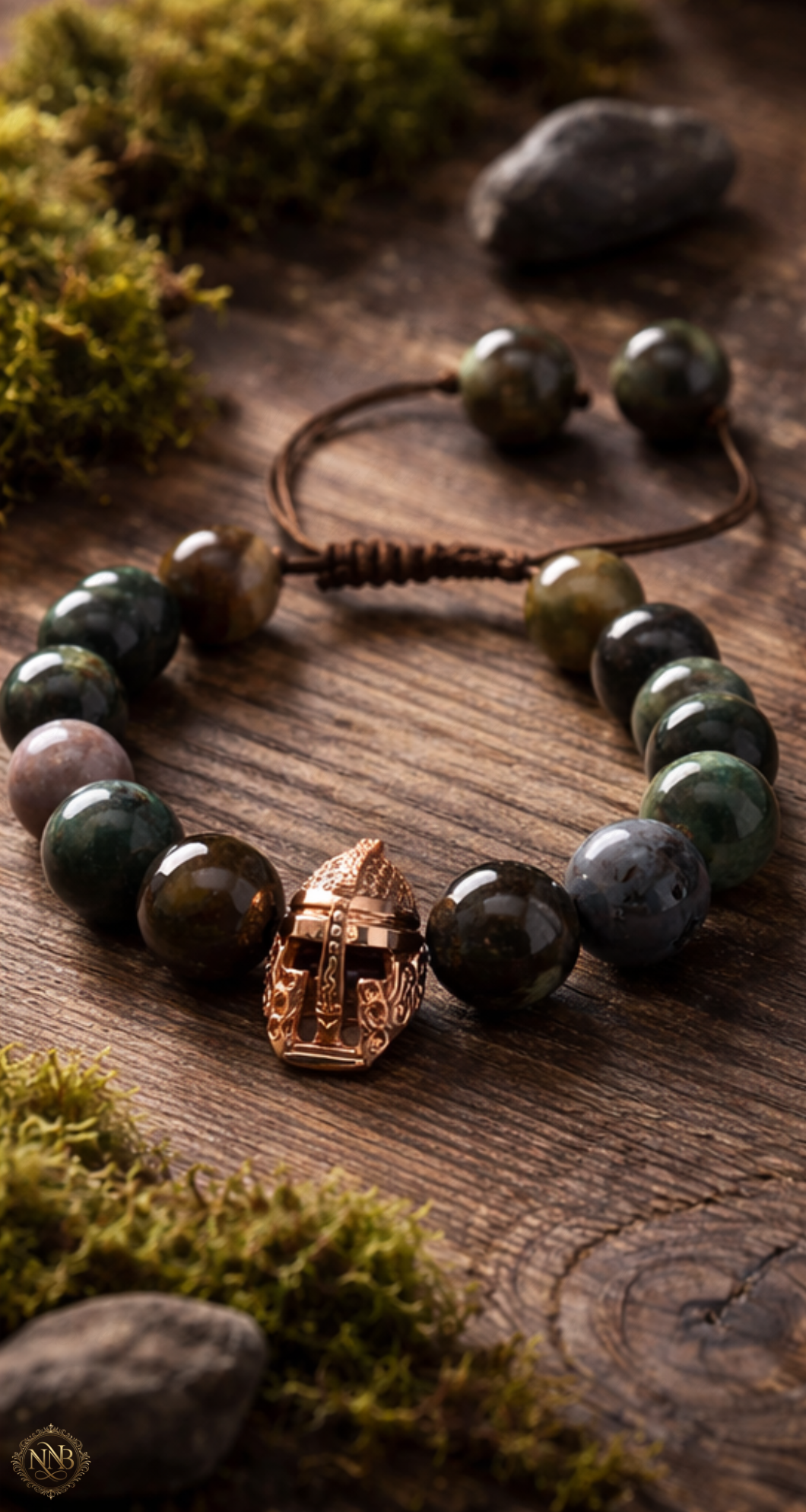 12mm natural agate stone bead bracelet with adjustable brown cord and rose gold tone Viking helmet centerpiece, styled on rustic wood with moss accents in natural warm lighting.