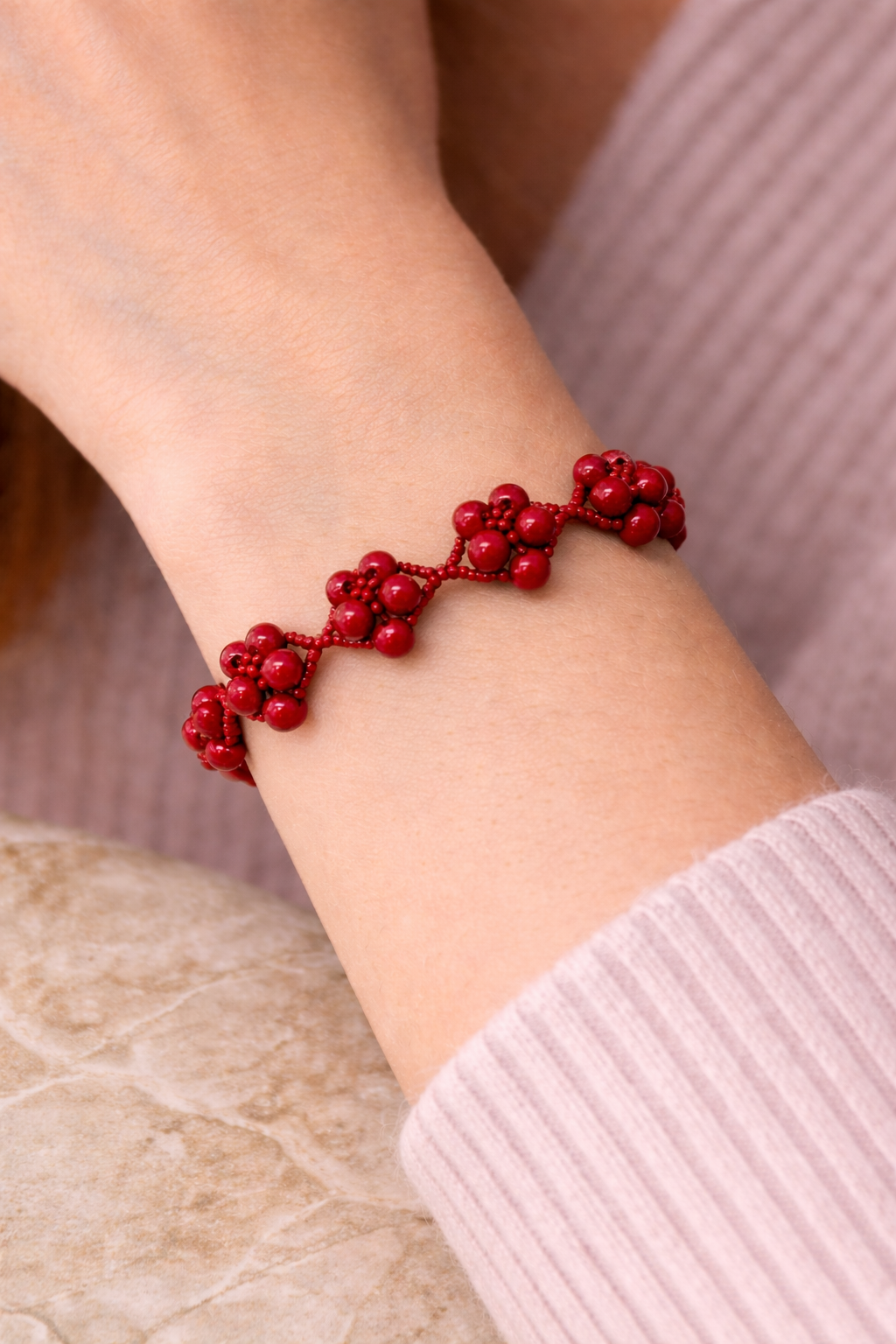 7.5 inch handmade red beaded bracelet with dimensional cluster design and silver heart toggle clasp styled on soft linen surface for luxury jewelry display