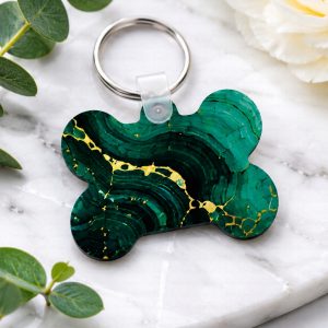 Emerald marble luxury bone-shaped pet ID tag with gold veining and silver key ring on a white background.